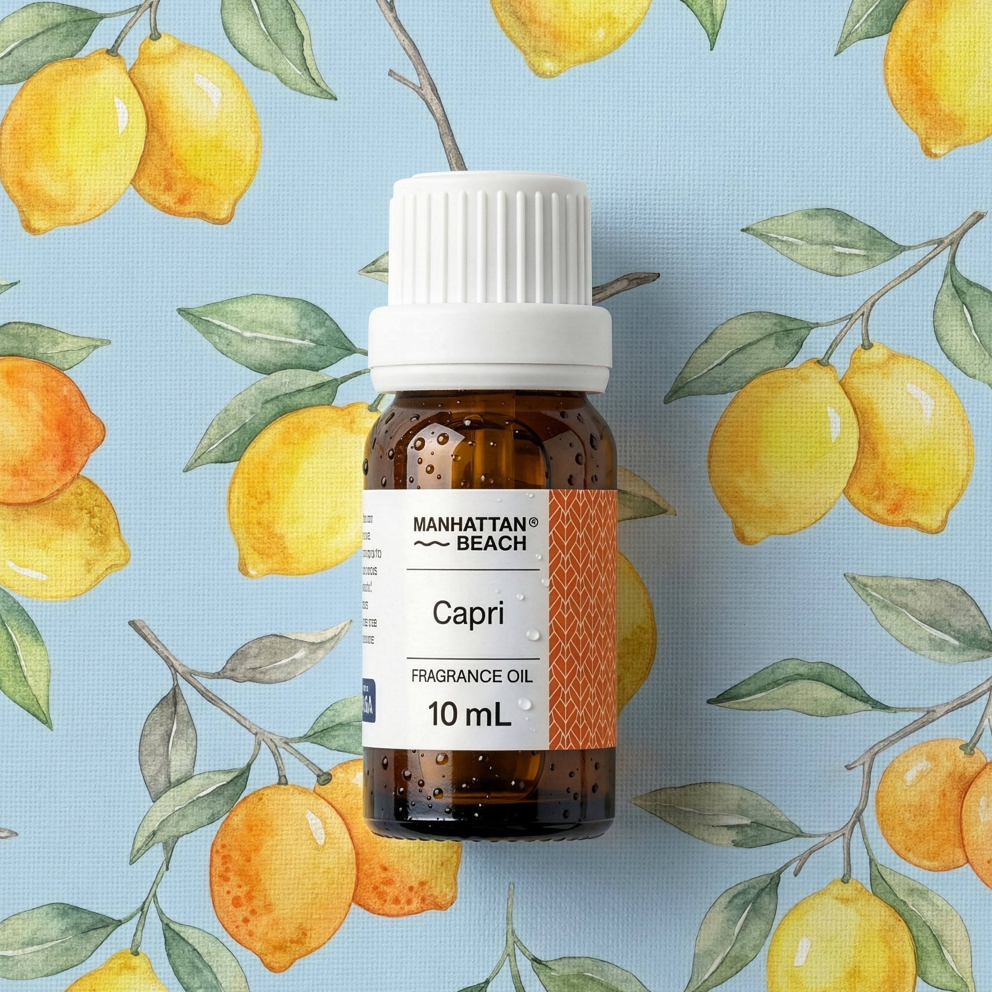Bottle of Manhattan Beach Capri fragrance oil with lemon illustrations on a blue background