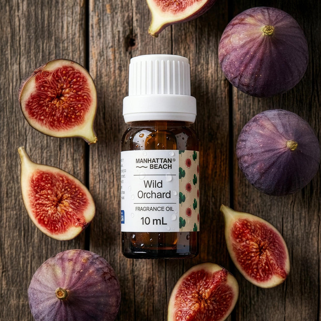 Bottle of Manhattan Beach Wild Orchard fragrance oil surrounded by sliced figs on a wooden surface