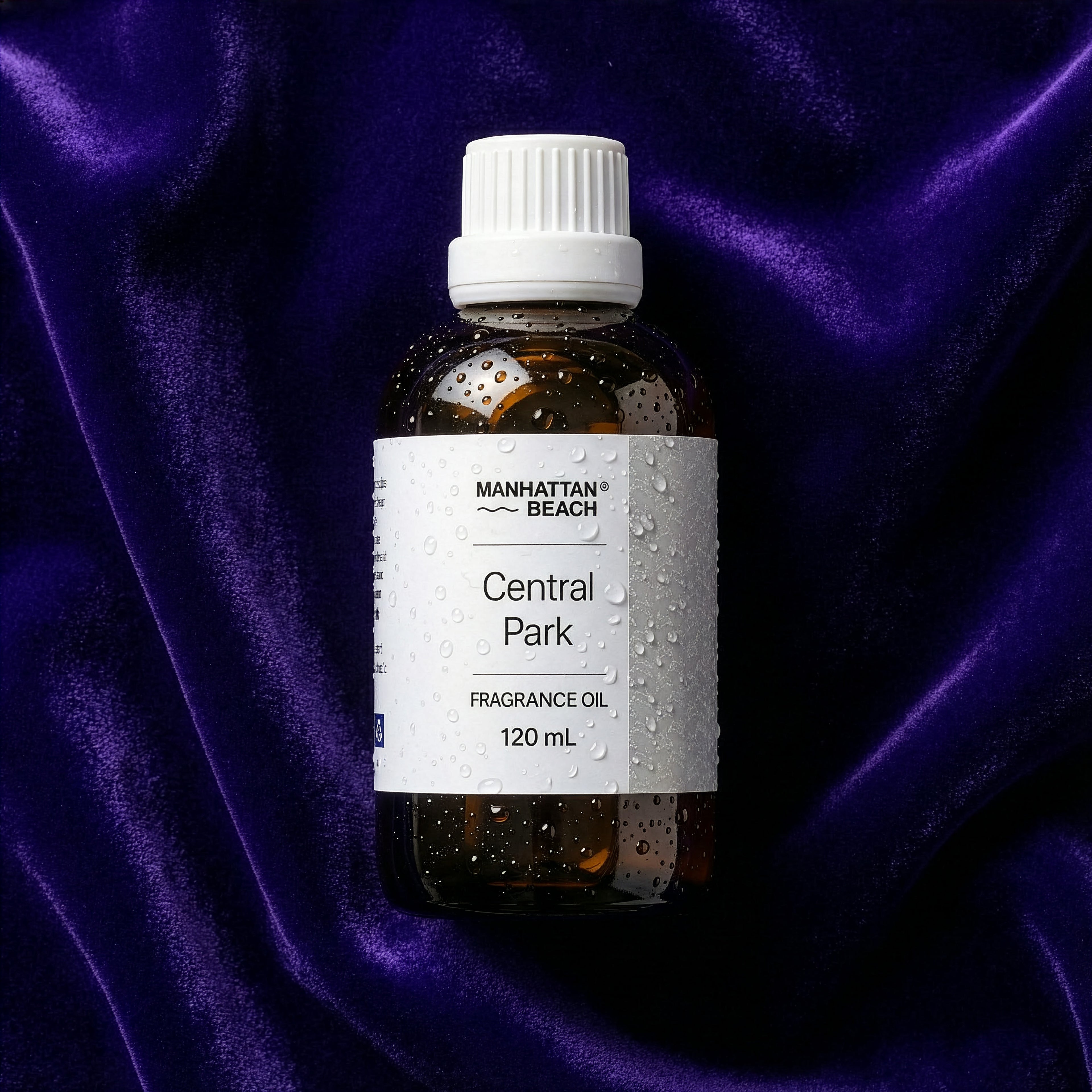 Bottle of Manhattan Beach Central Park fragrance oil on a purple fabric background