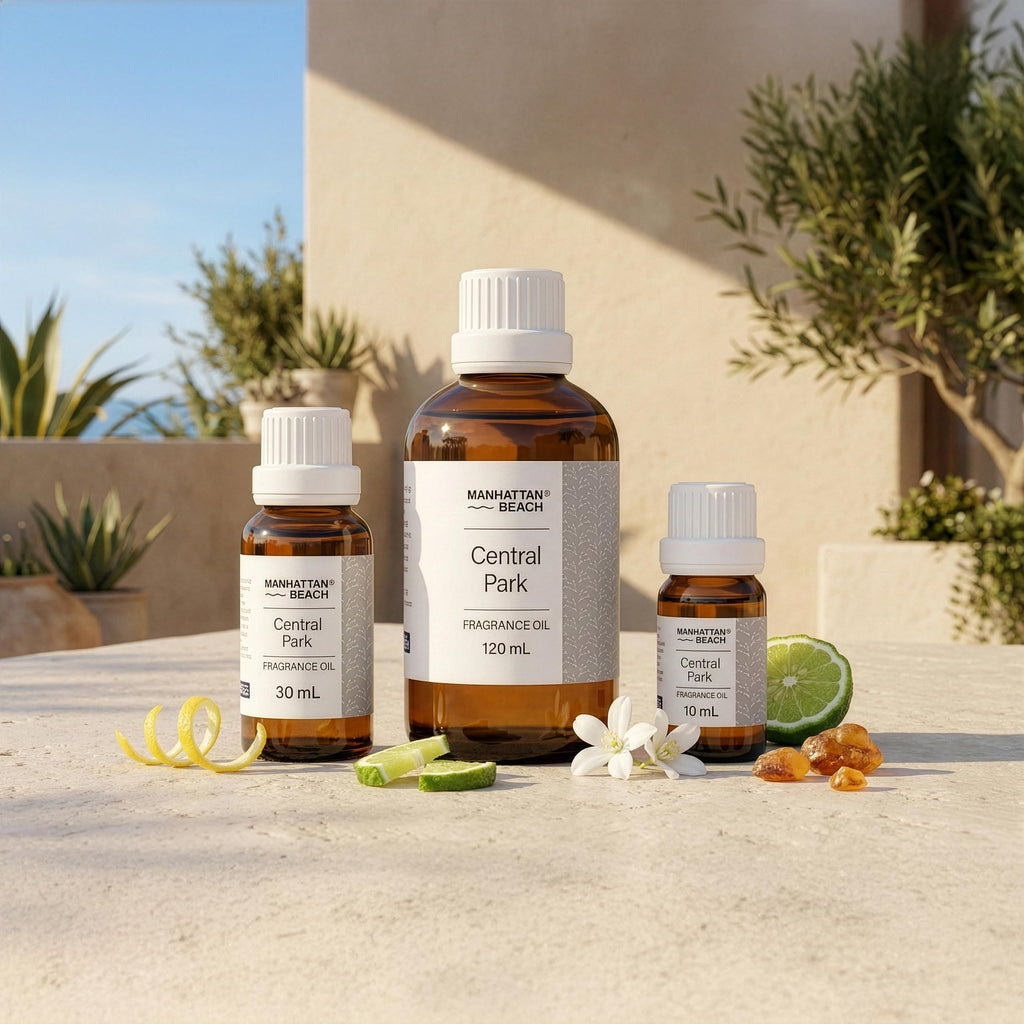 Three bottles of Manhattan Beach Central Park fragrance oil on a surface with plants in the background.