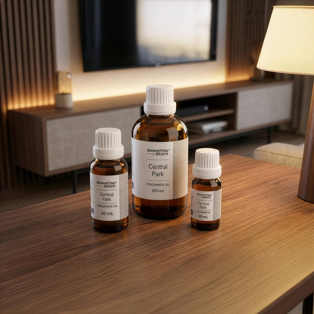 Three bottles of Manhattan Beach Central Park fragrance oil on a wooden table with a home interior background.