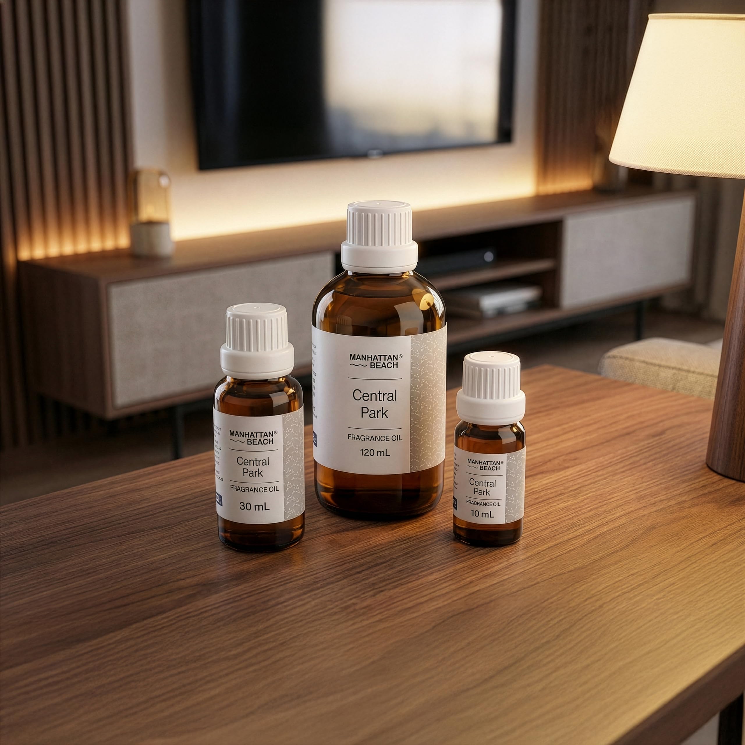 Three bottles of Manhattan Beach Central Park fragrance oil on a wooden table with a home interior background.